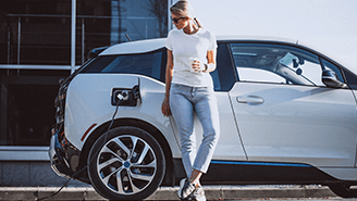 a woman leaning against a charging car