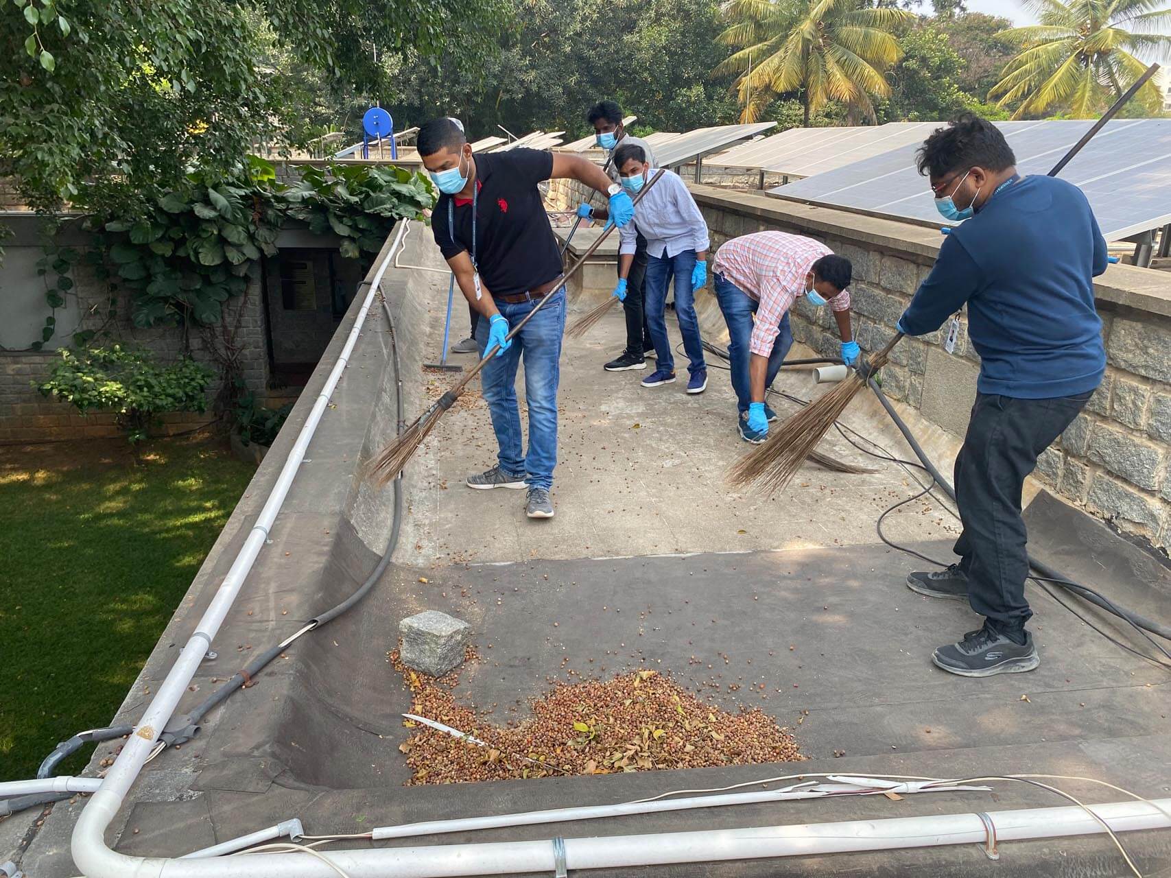 a group of people sweeping a roof