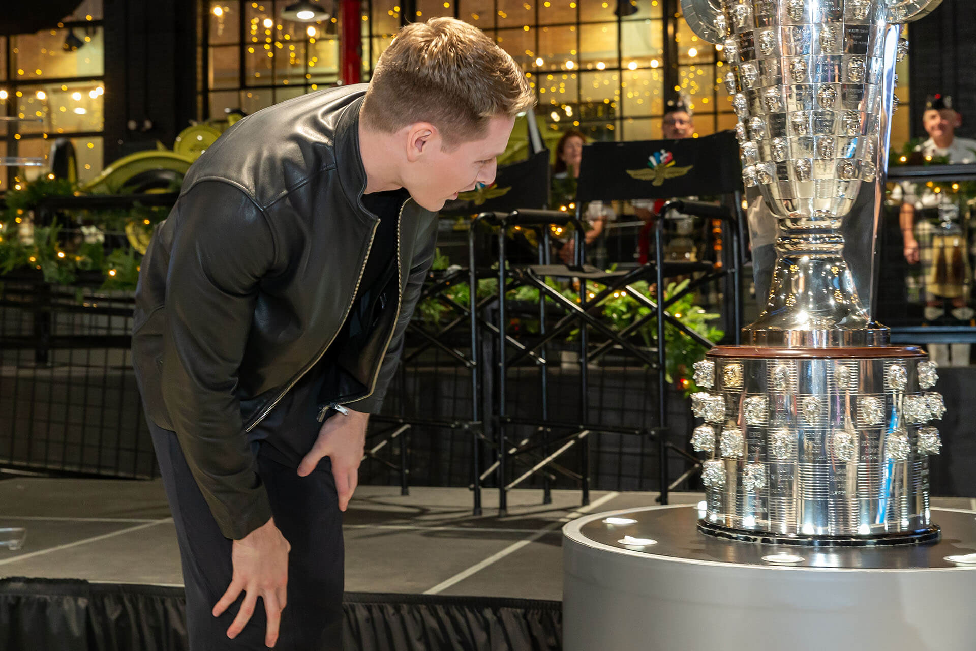 Man in awe looking at tall silver trophy