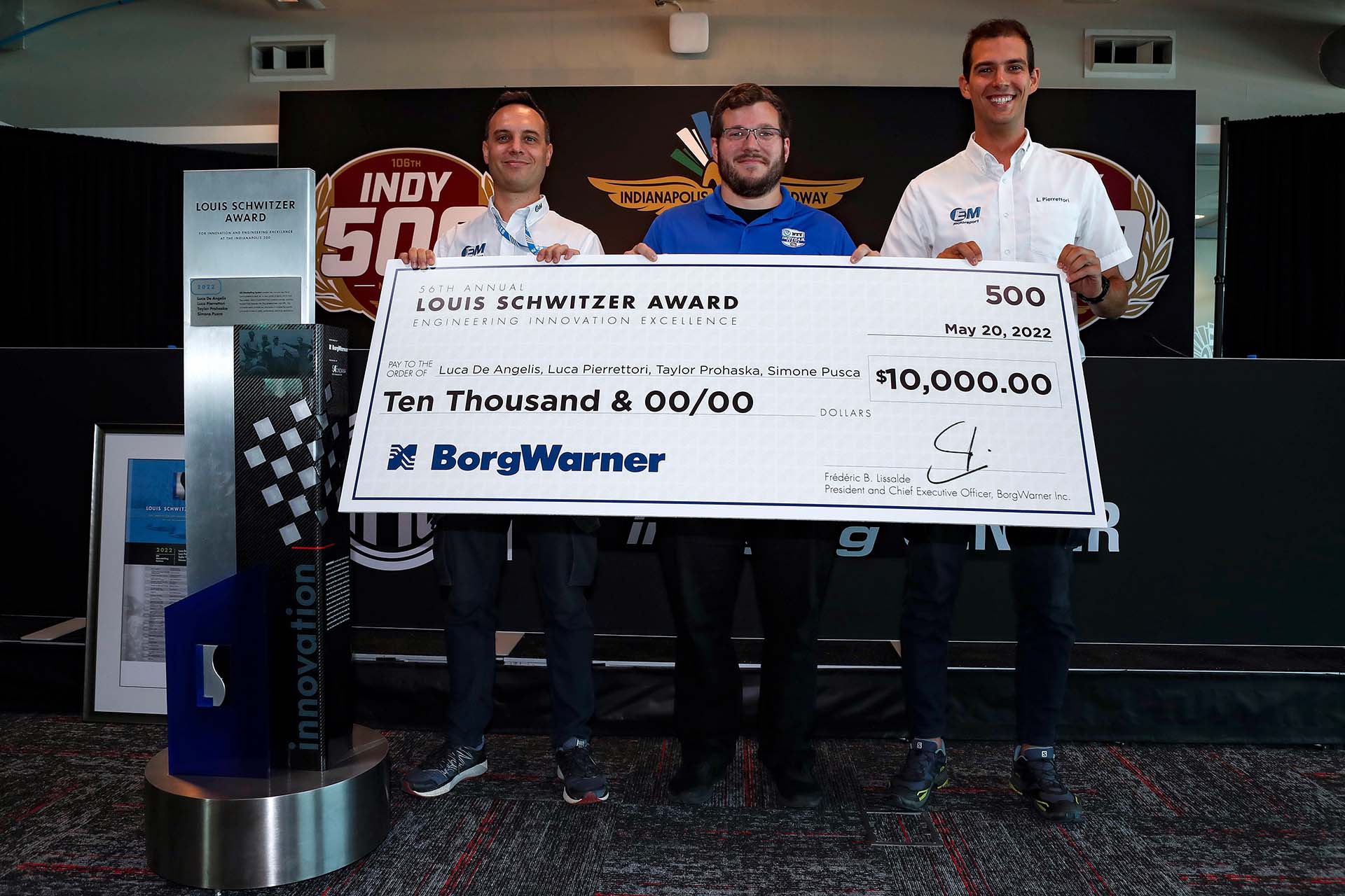 Three men hold large check for 10,000 USD