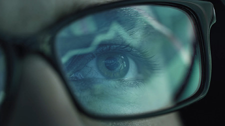 Closeup of a human eye with glasses stock market figured are mirrored in the glass